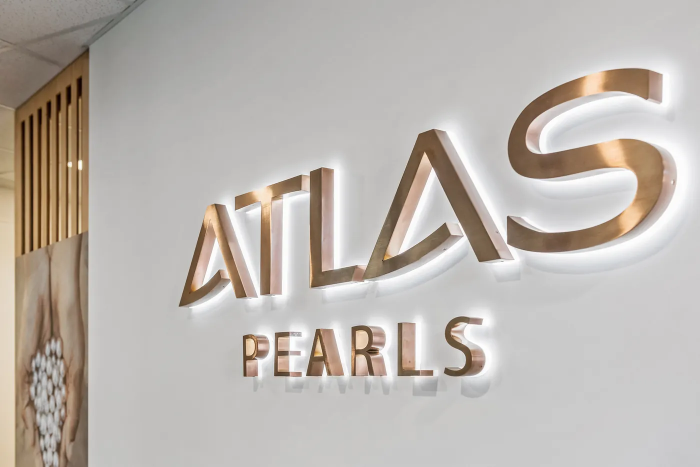 Atlas Pearls — Brushed brass Atlas Pearls signage detail.