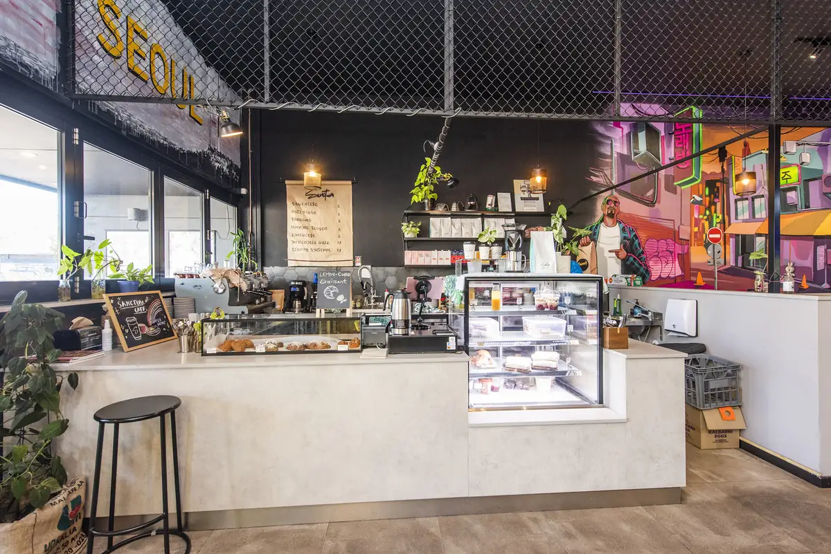 Sanctum Cafe &mdash; servery counter and display cabinet beneath exposed services