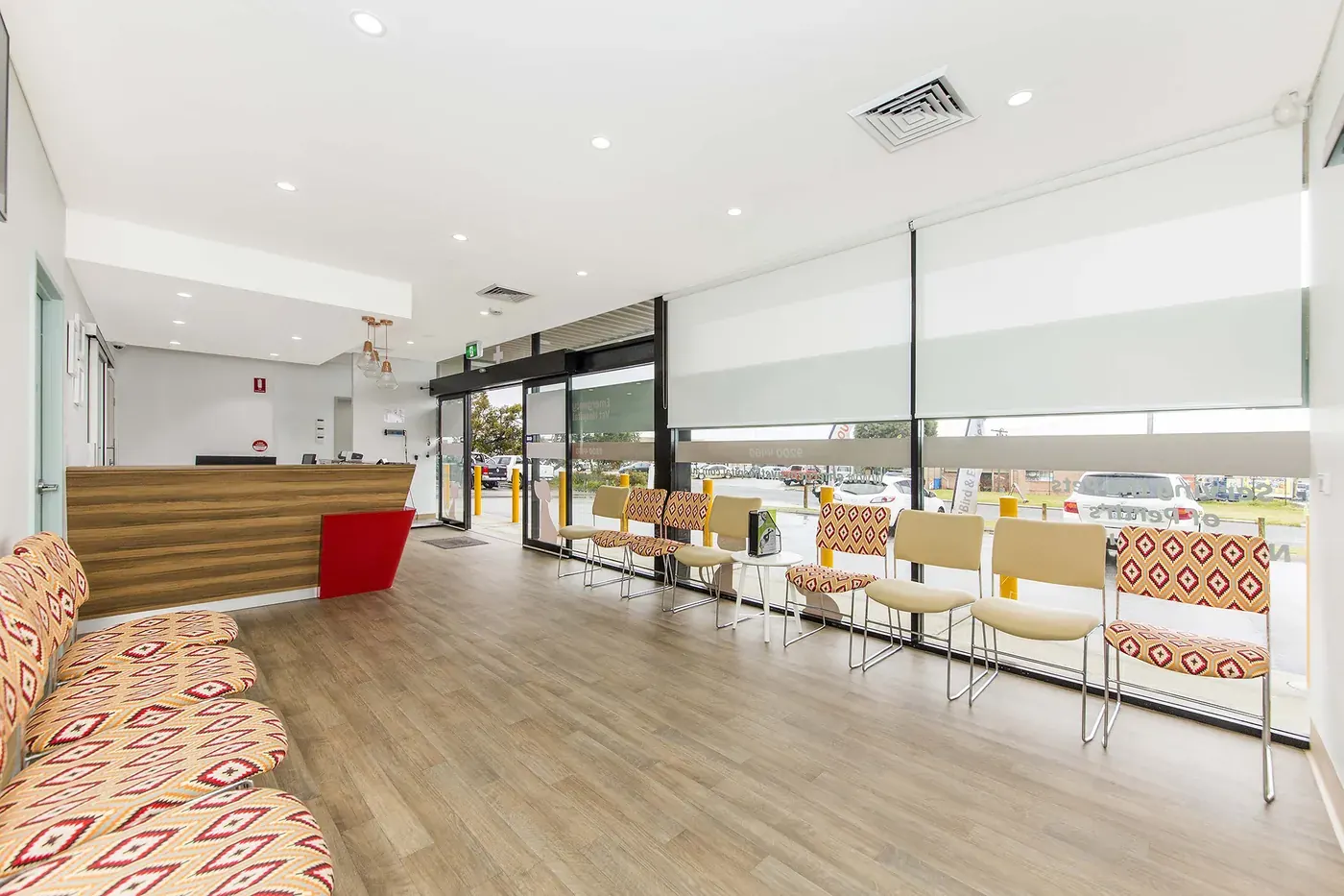 Emergency Vet Hospital — Daylit waiting area with timber floor and patterned seating.